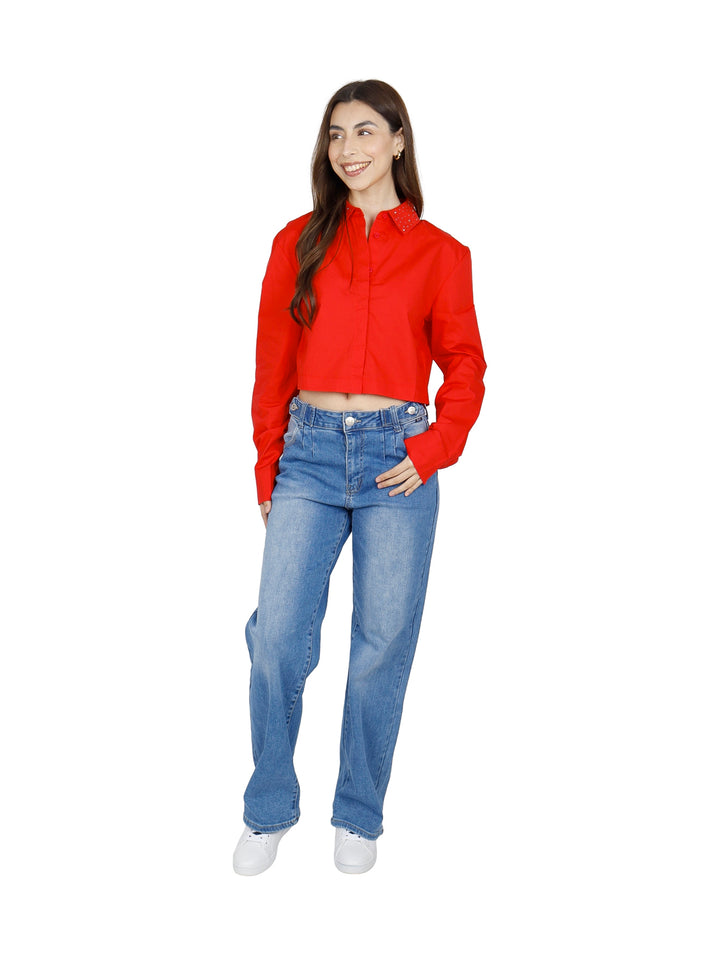 Mujer vistiendo una camisa roja corta de manga larga con botones.