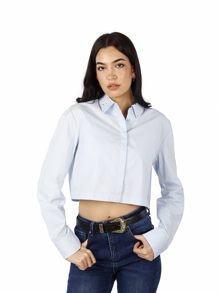 Mujer vistiendo una camisa cropped de color azul claro con manga larga y cuello.