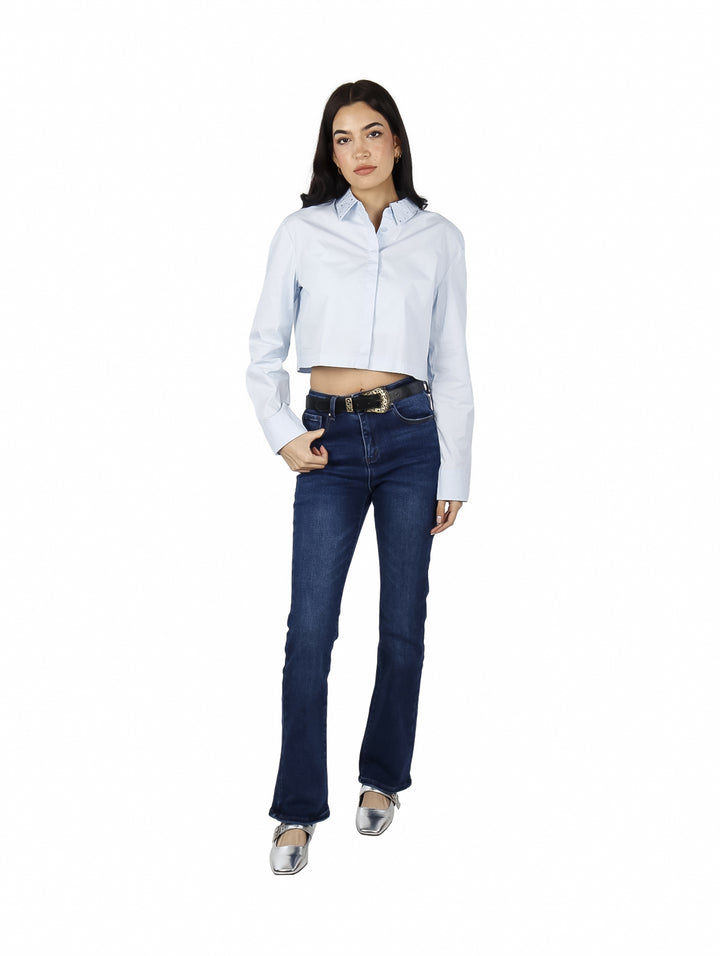 Mujer vistiendo una camisa cropped de color azul claro con manga larga y cuello.