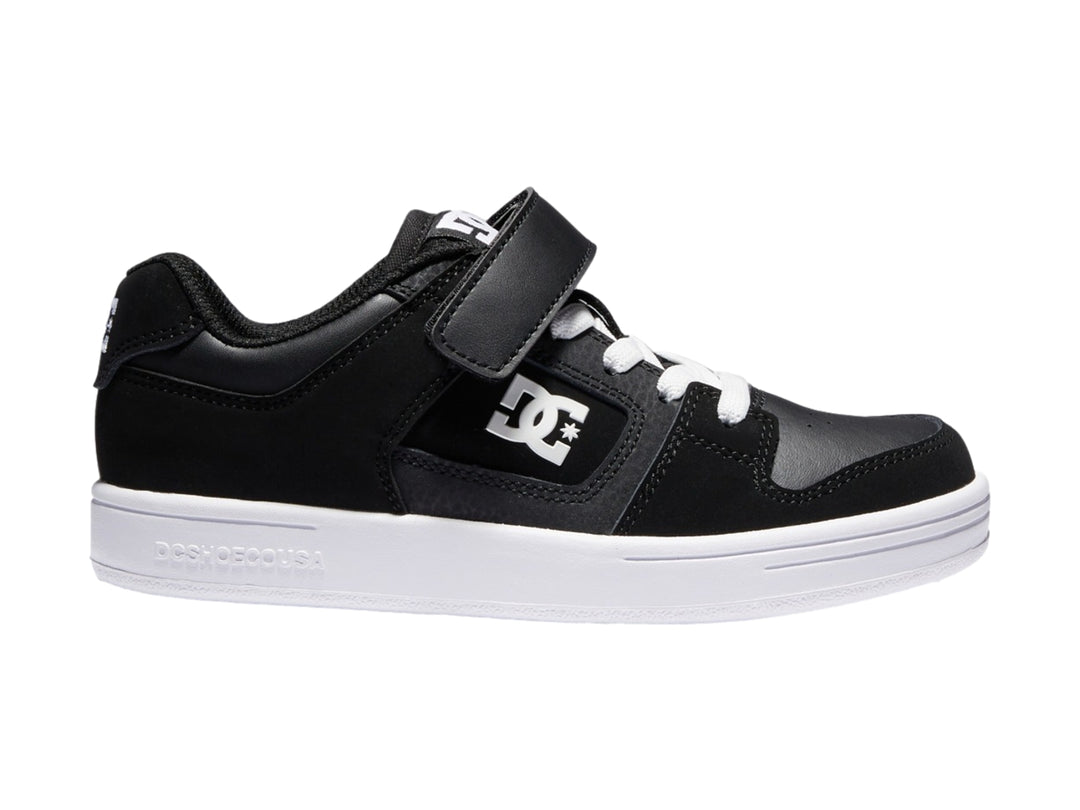 Tenis DC Shoes para niño en color negro y blanco con cierre de velcro y suela blanca.