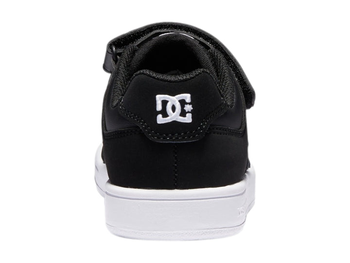 Tenis DC Shoes para niño en color negro y blanco con cierre de velcro y suela blanca.
