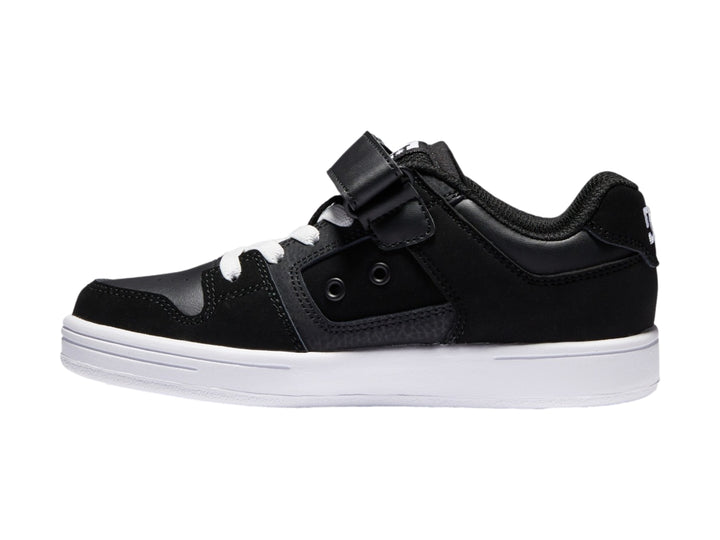 Tenis DC Shoes para niño en color negro y blanco con cierre de velcro y suela blanca.