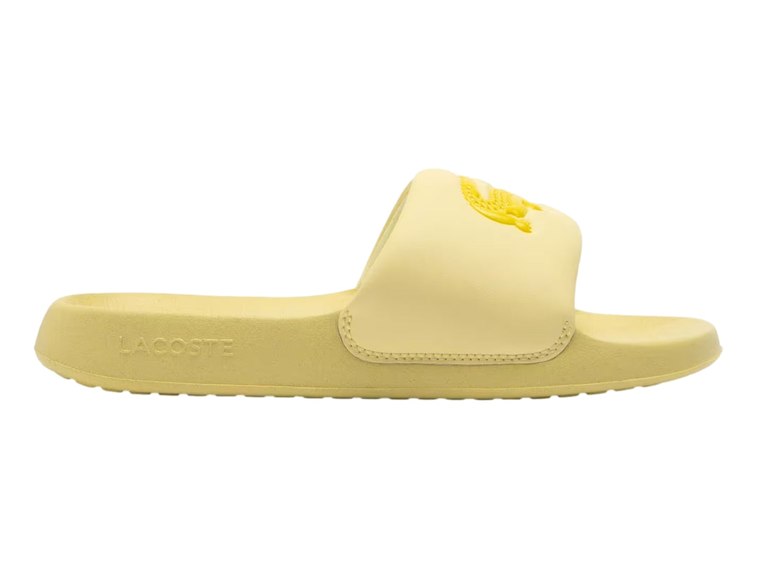Sandalia slide Lacoste de color amarillo claro con logotipo bordado en la banda superior.