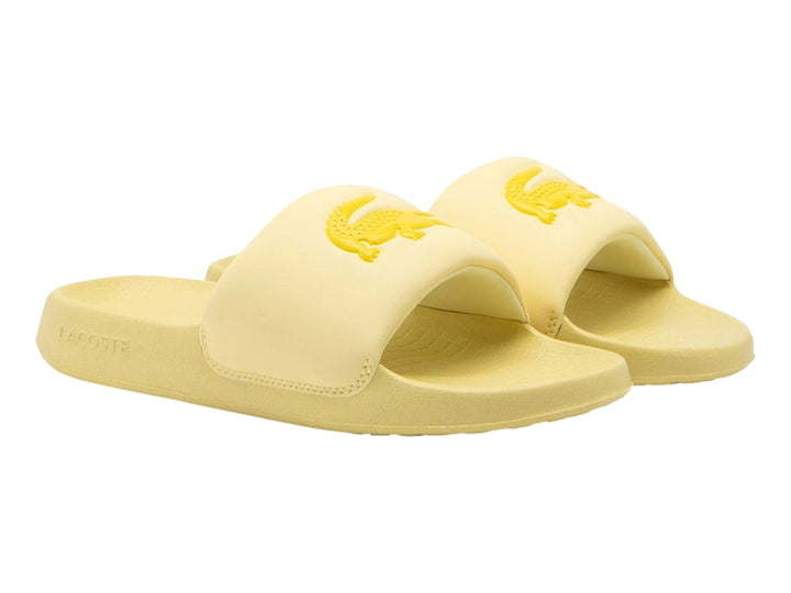 Sandalia slide Lacoste de color amarillo claro con logotipo bordado en la banda superior.