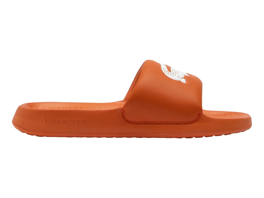 Sandalia deslizante Lacoste de color naranja con logotipo blanco en la banda superior.