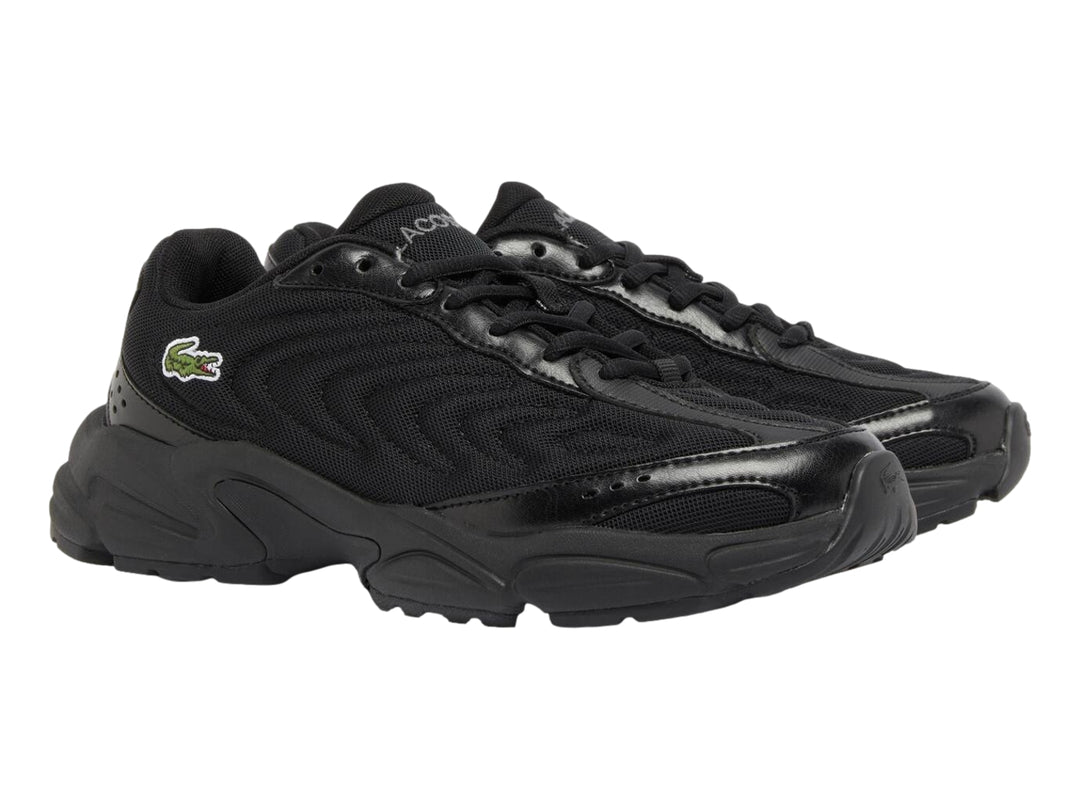 Tenis deportivos Lacoste color negro con suela gruesa y detalles sintéticos.