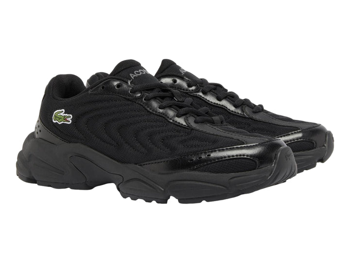 Tenis deportivos Lacoste color negro con suela gruesa y detalles sintéticos.