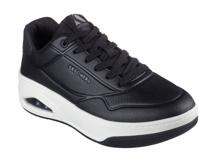 Tenis Skechers Uno Court color negro con suela blanca y cámara de aire visible en el talón.