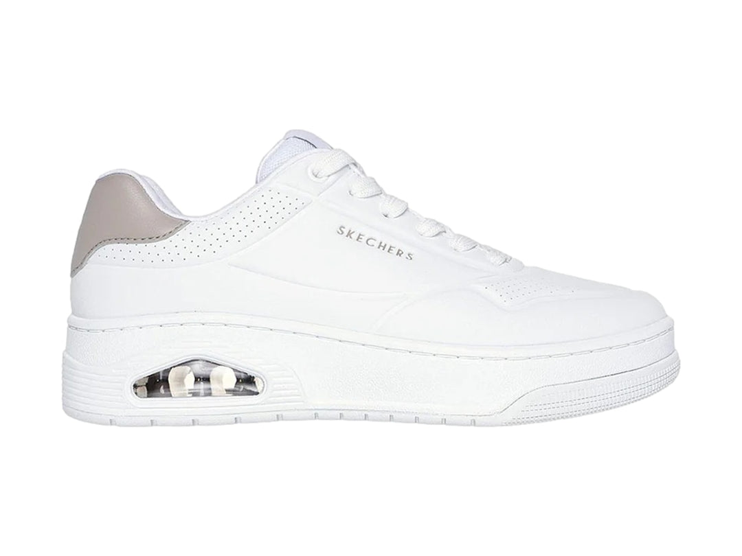 Tenis blancos Skechers Uno Court con detalle gris en el talón y cámara de aire visible en la suela.