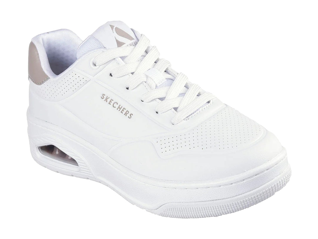 Tenis blancos Skechers Uno Court con detalle gris en el talón y cámara de aire visible en la suela.