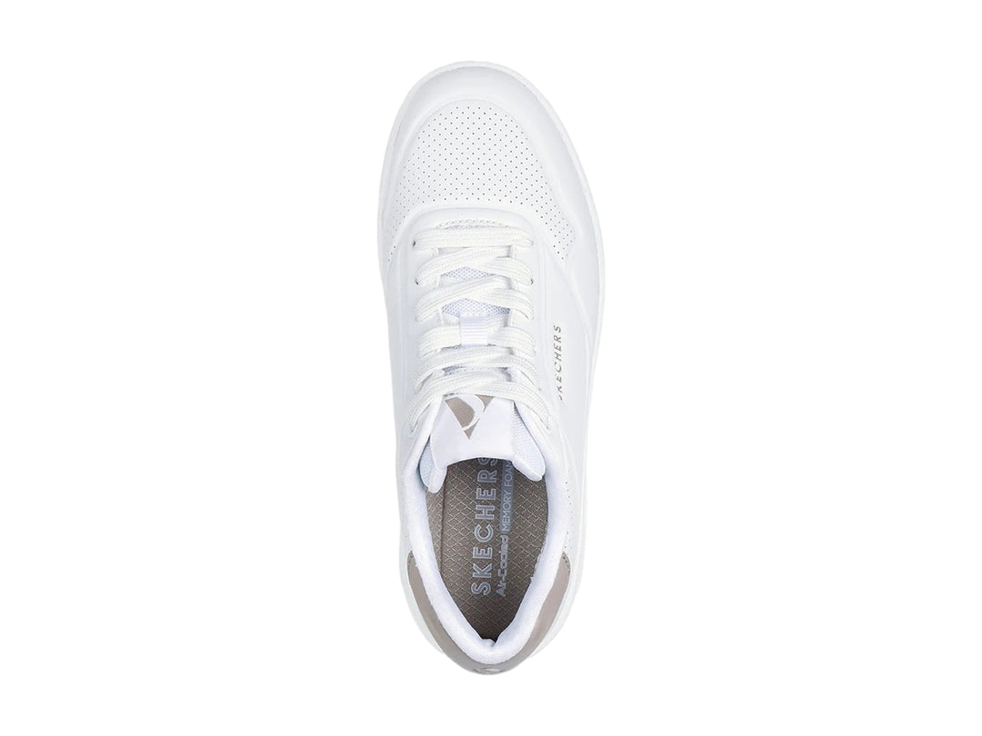 Tenis blancos Skechers Uno Court con detalle gris en el talón y cámara de aire visible en la suela.