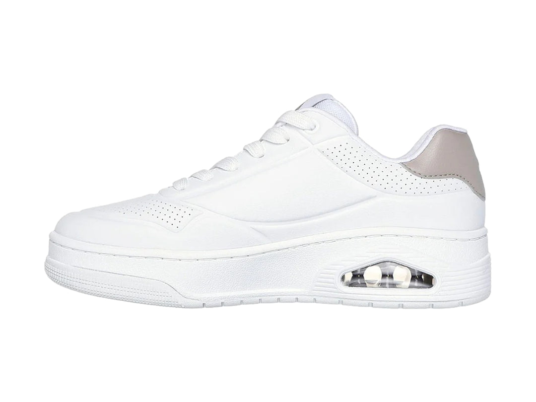 Tenis blancos Skechers Uno Court con detalle gris en el talón y cámara de aire visible en la suela.