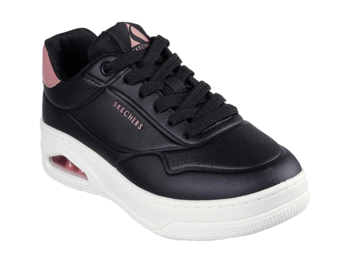 Tenis Skechers color negro con suela blanca y detalle en rosa en el talón.