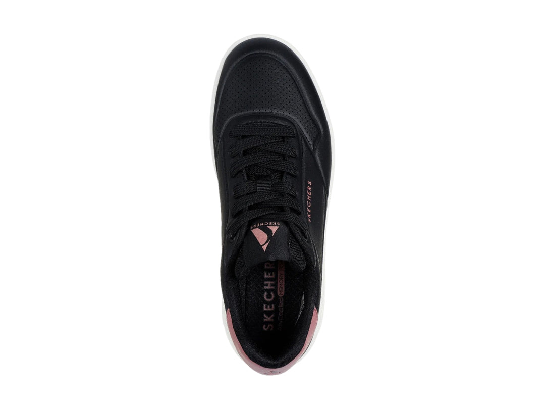 Tenis Skechers color negro con suela blanca y detalle en rosa en el talón.