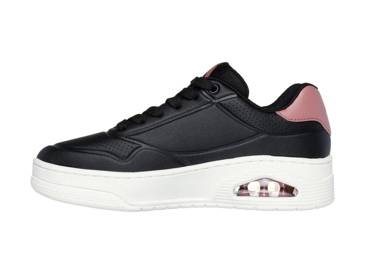 Tenis Skechers color negro con suela blanca y detalle en rosa en el talón.