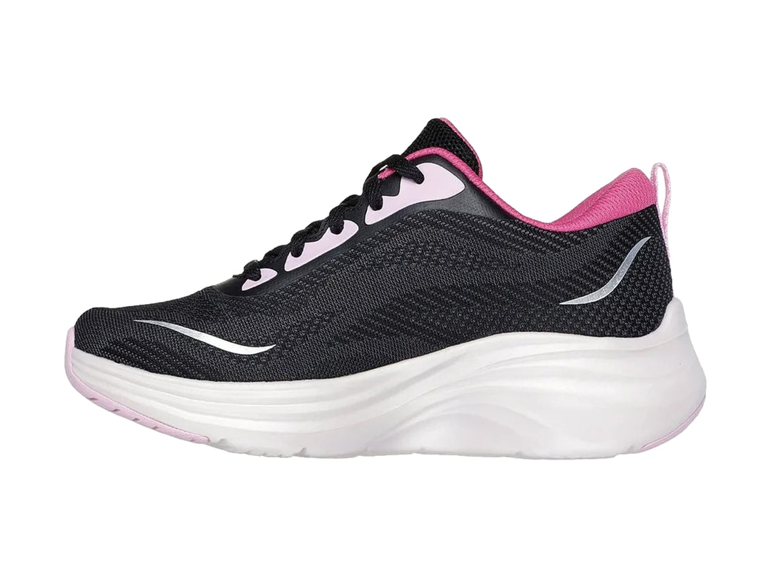 Tenis deportivos Skechers color negro con suela blanca y detalles en rosa.