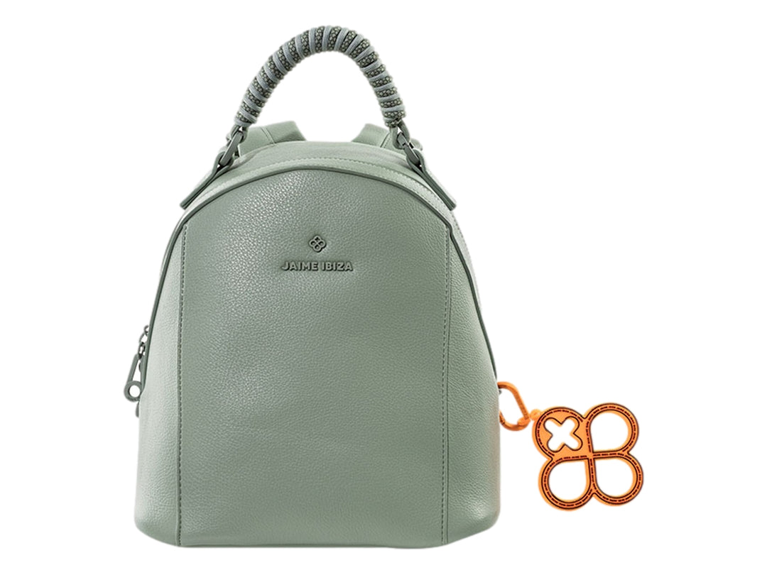Mochila verde de Jaime Ibiza con asa superior y un accesorio colgante de color naranja.