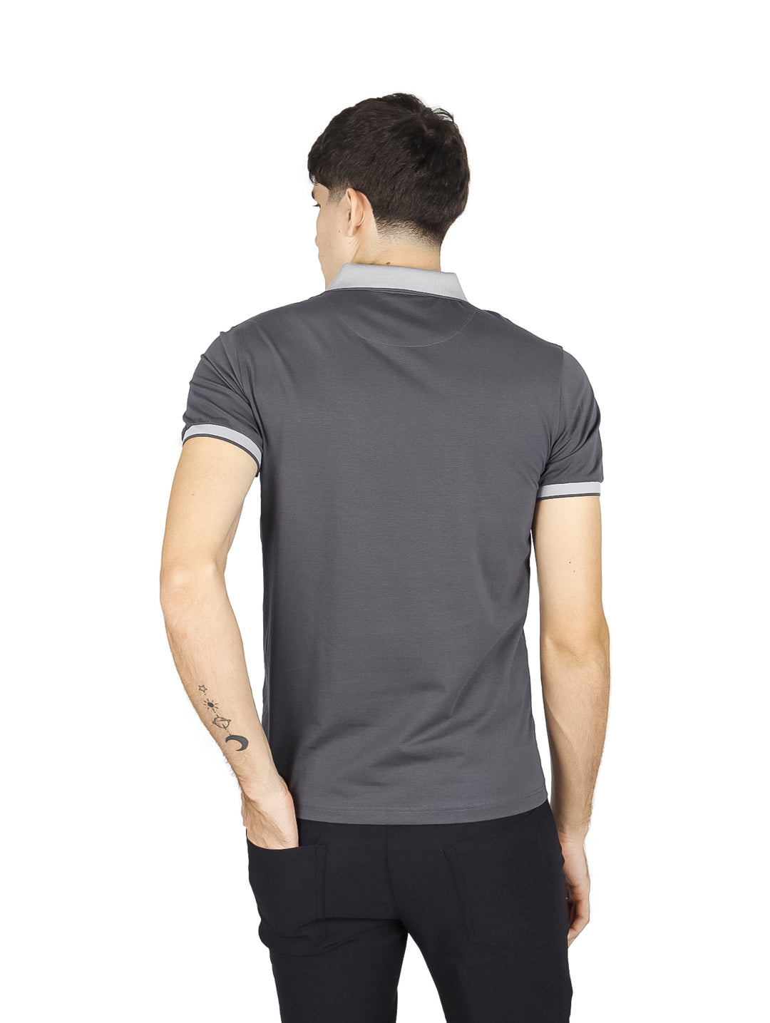 Hombre vistiendo playera polo color charcoal con detalles en gris claro en el cuello y los bordes de las mangas.
