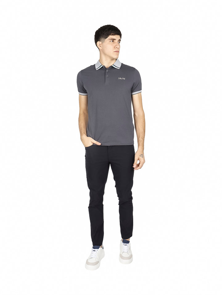 Hombre vistiendo playera polo color charcoal con detalles en gris claro en el cuello y los bordes de las mangas.
