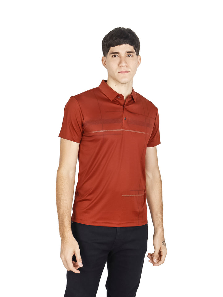 Hombre vistiendo una playera polo de color terracota y pantalones negros sobre fondo blanco.