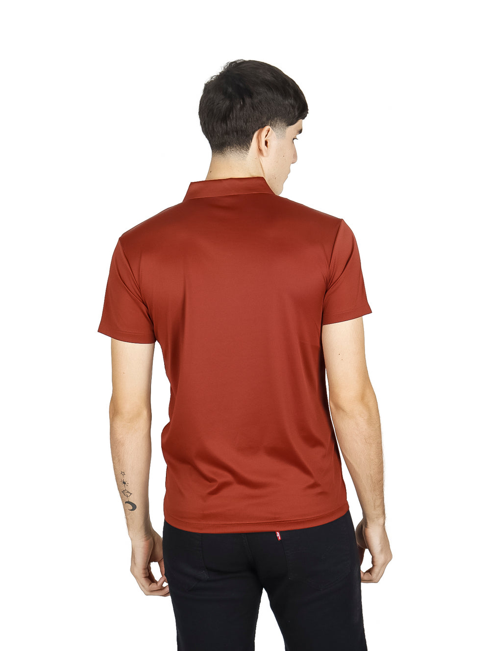 Hombre vistiendo una playera polo de color terracota y pantalones negros sobre fondo blanco.