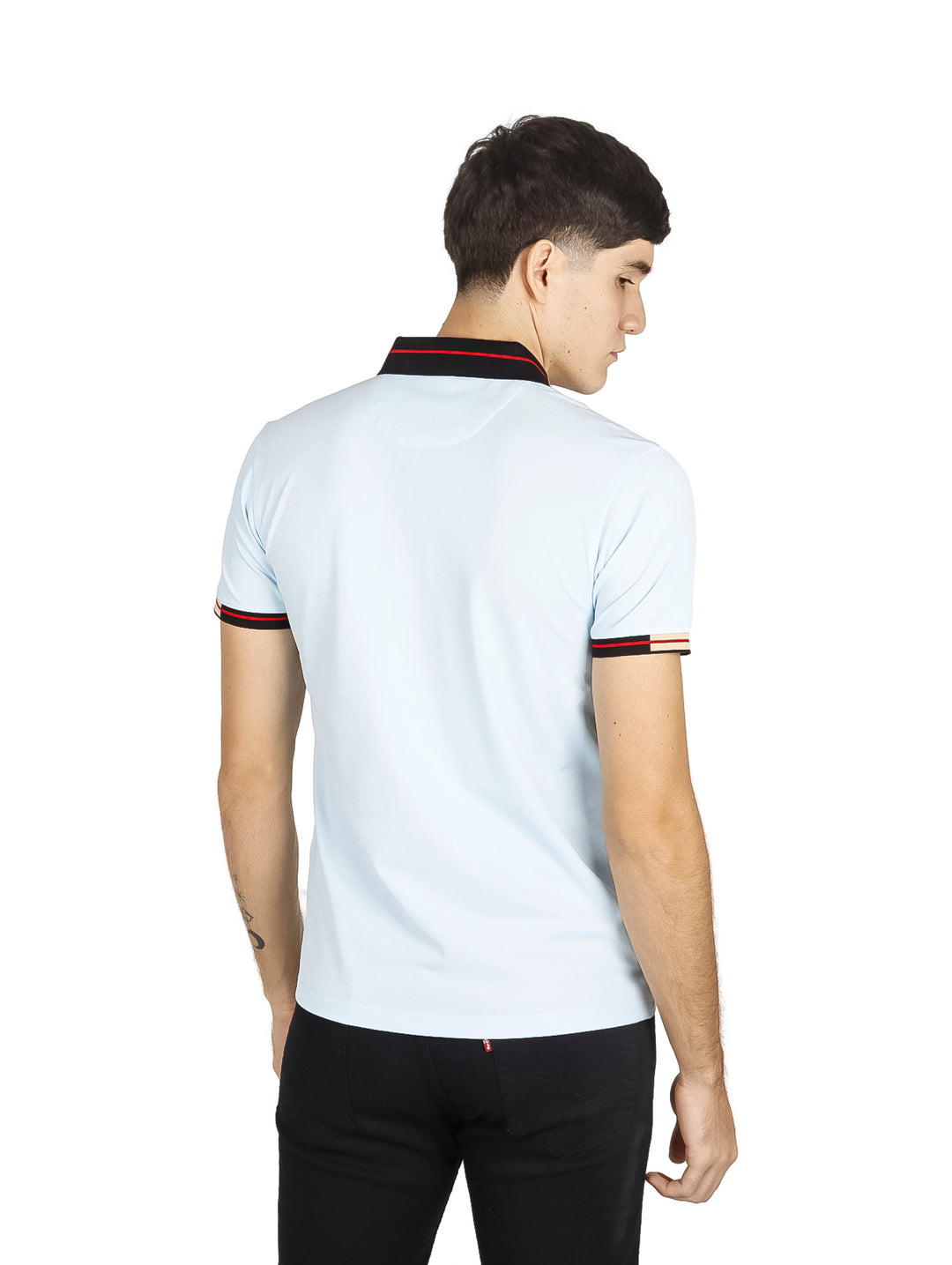 Hombre vistiendo playera polo color azul cielo con detalles negros y rojos en el cuello y mangas.