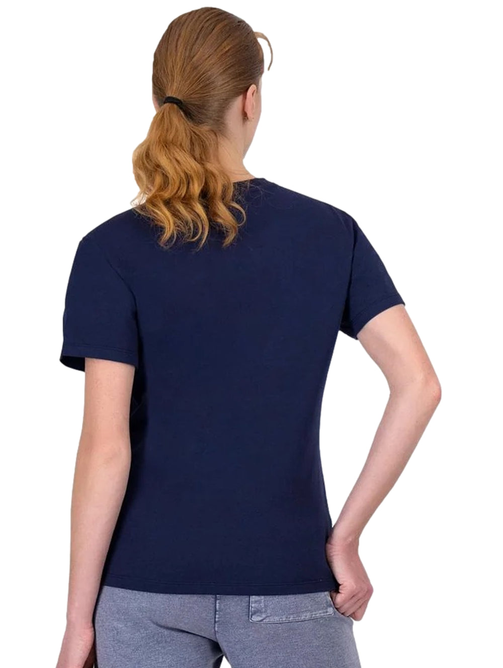 Mujer vistiendo playera Champion azul marino con un diseño de flor roja en el pecho.