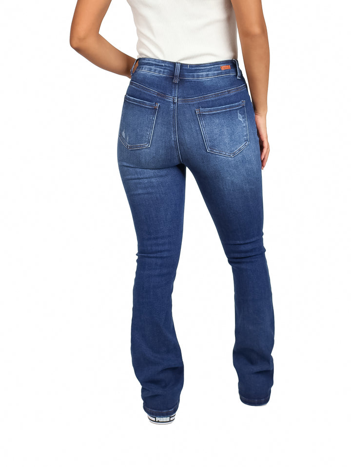 Mujer vistiendo pantalones KAHUA JEANS modelo KA274 en color azul stone con corte flare y calzado blanco.