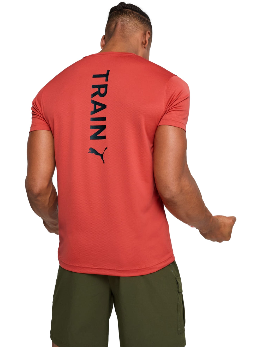 Hombre vistiendo una camiseta deportiva PUMA de color rojo fuego con logo 'TRAIN' en el pecho.