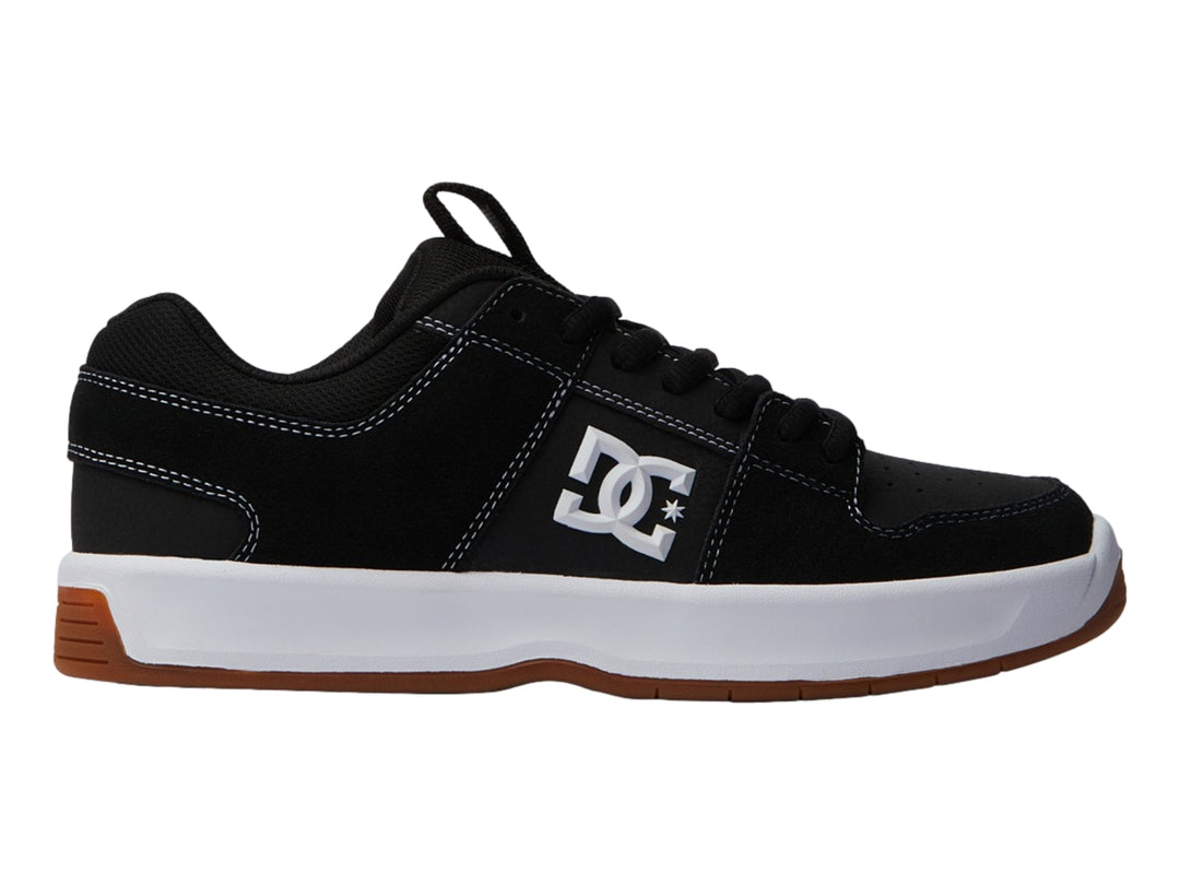 Tenis DC Shoes color negro con suela blanca y base café, vista lateral.