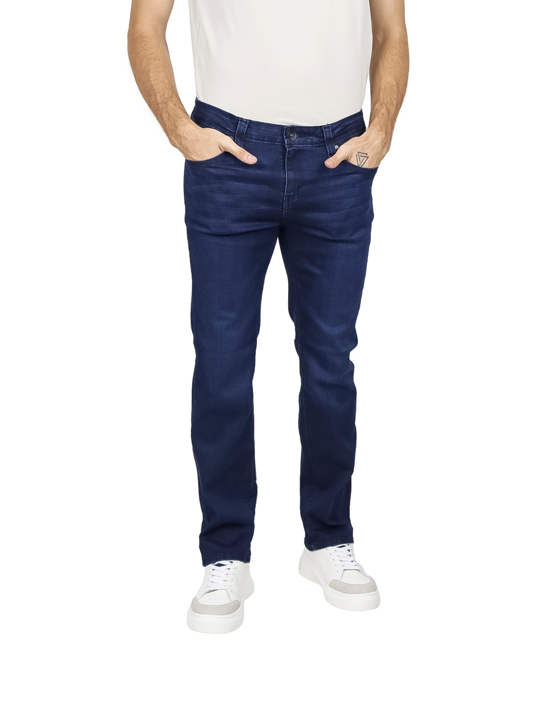 Hombre vistiendo pantalones jeans azul oscuro de corte recto y tenis blancos.