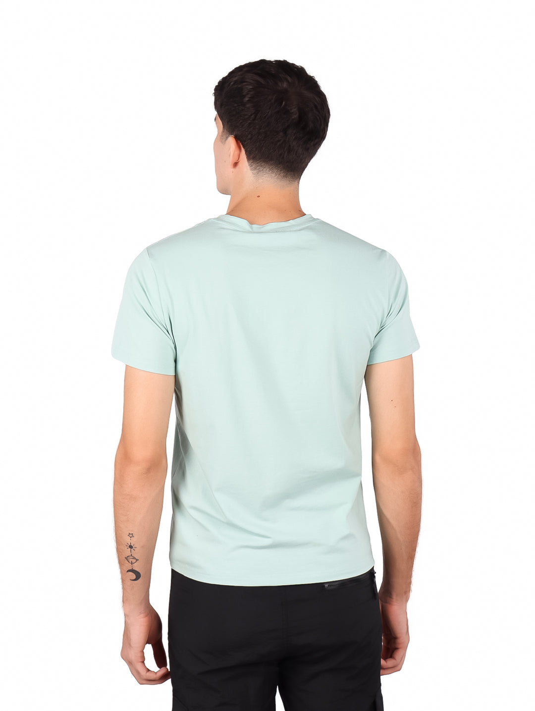 Hombre vistiendo playera de manga corta color verde menta con un pequeño logo en el pecho.