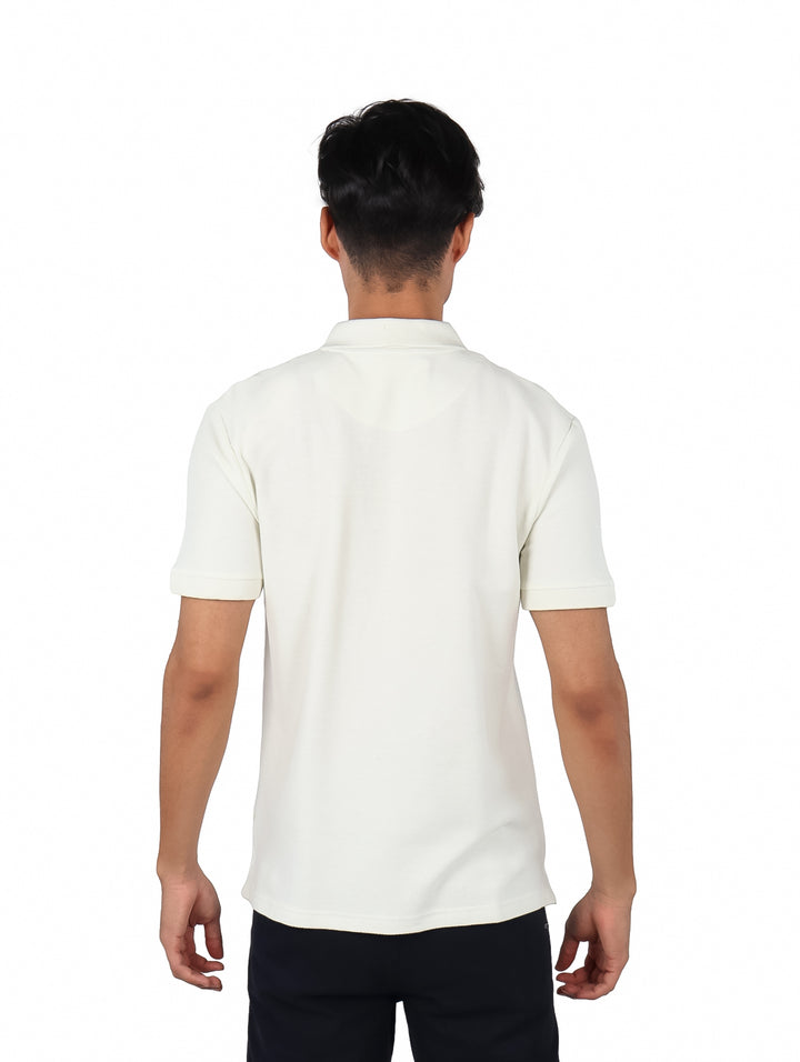 Hombre vistiendo playera polo color beige con cierre frontal y manga corta.