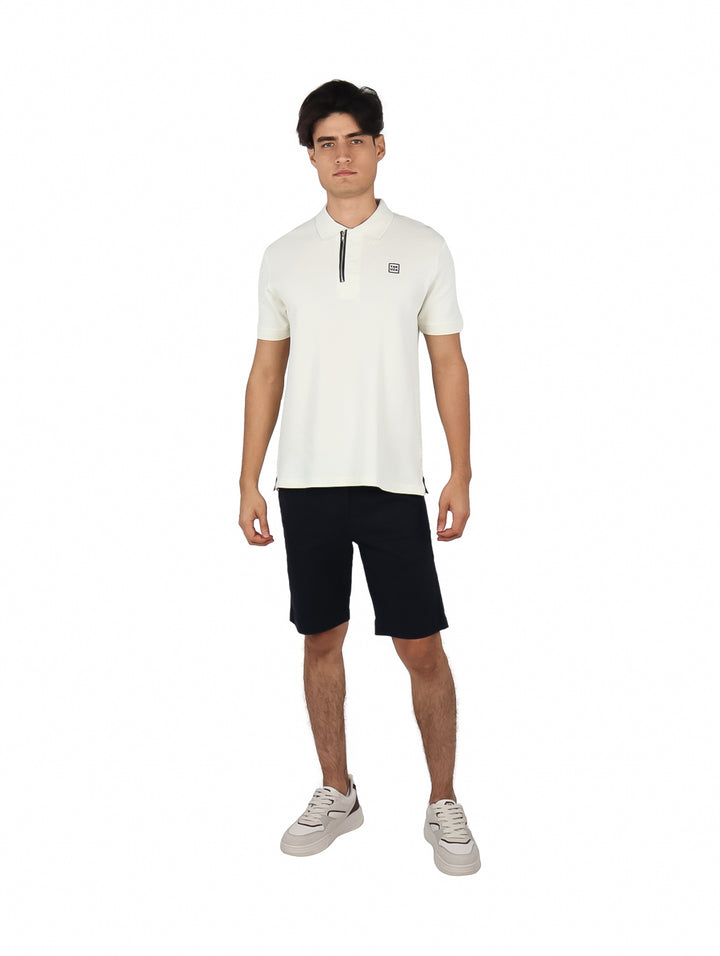 Hombre vistiendo playera polo color beige con cierre frontal y manga corta.