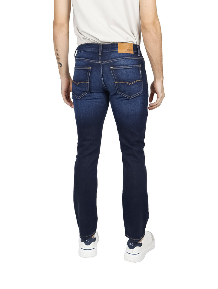Hombre vistiendo pantalones jeans OGGI en color azul oscuro Dark Stone.