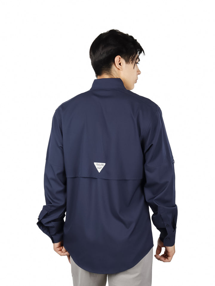 Hombre vistiendo una camisa de manga larga color azul marino con bolsillos frontales.