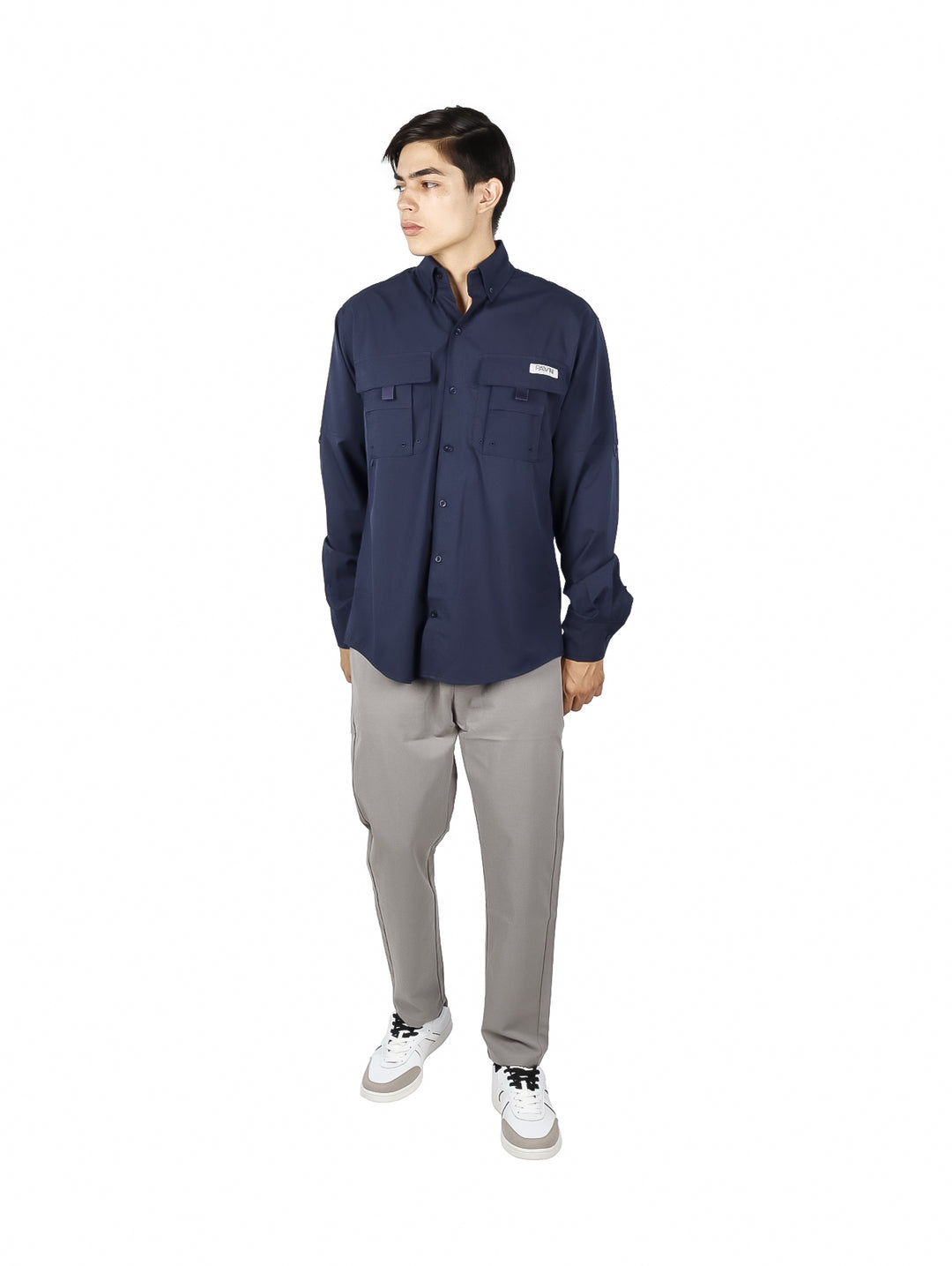 Hombre vistiendo una camisa de manga larga color azul marino con bolsillos frontales.