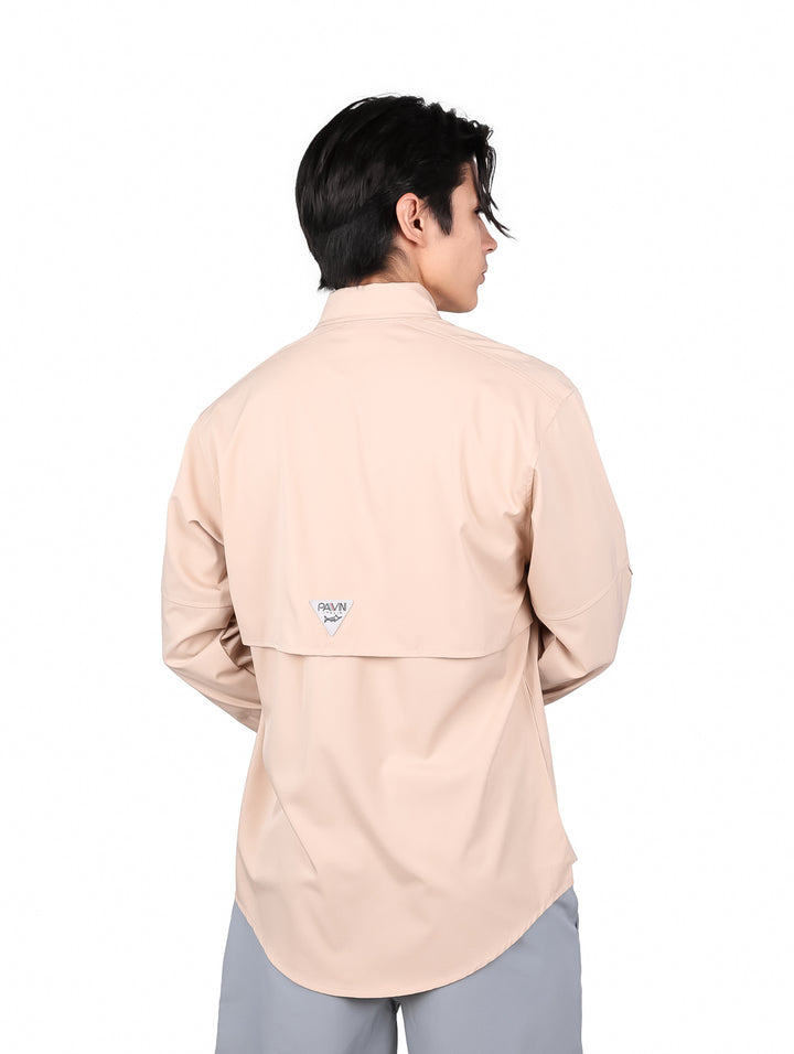 Hombre vistiendo una camisa color beige de manga larga con dos bolsillos frontales.