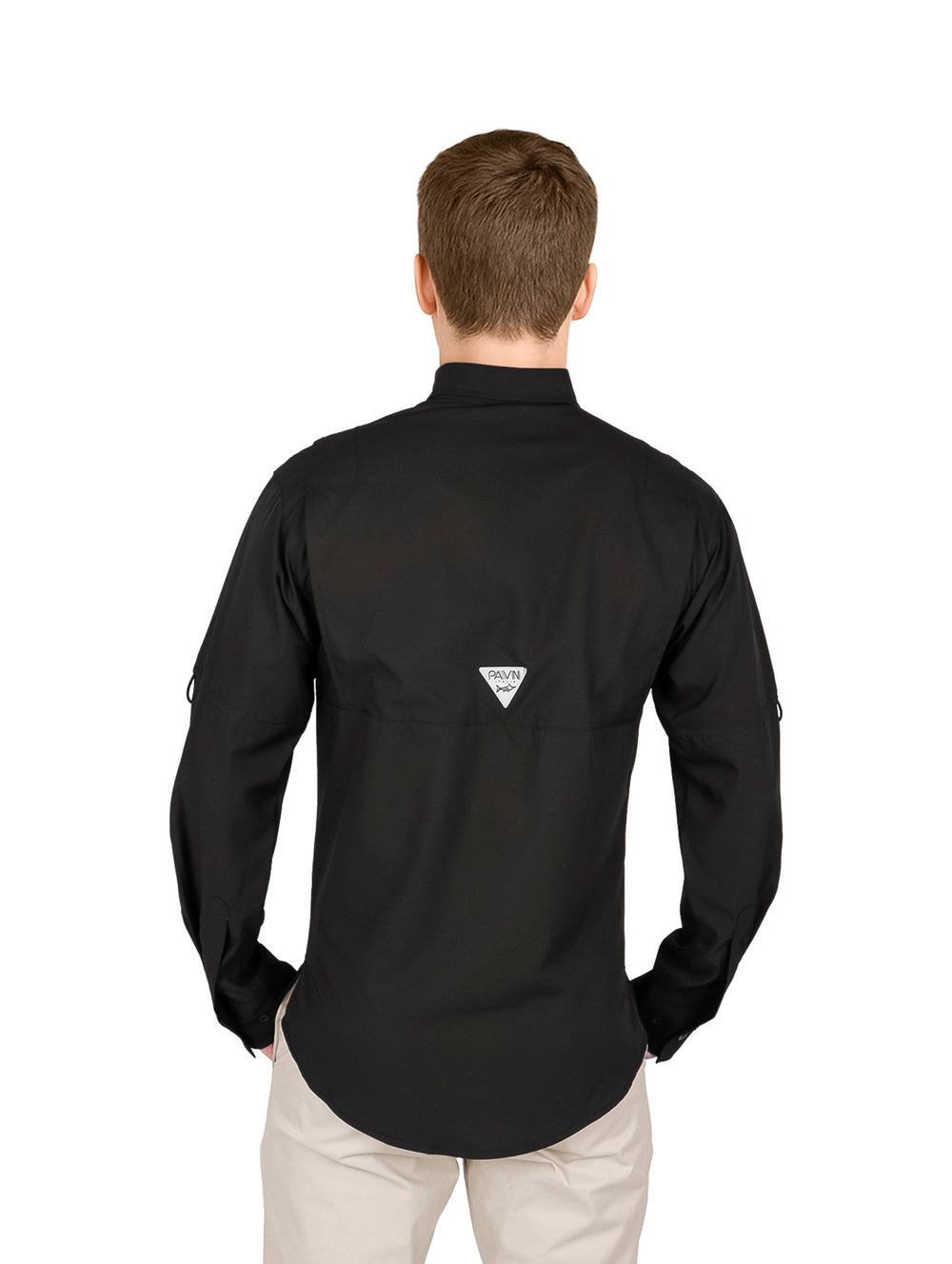 Hombre usando una camisa negra de manga larga y pantalones beige.