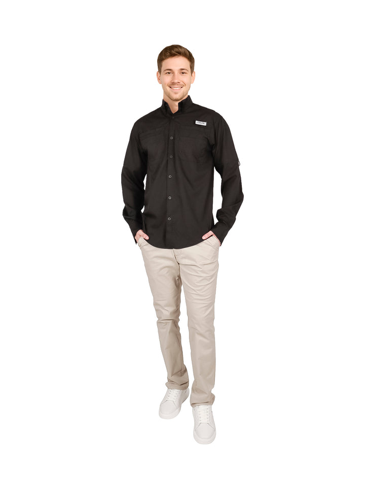 Hombre usando una camisa negra de manga larga y pantalones beige.