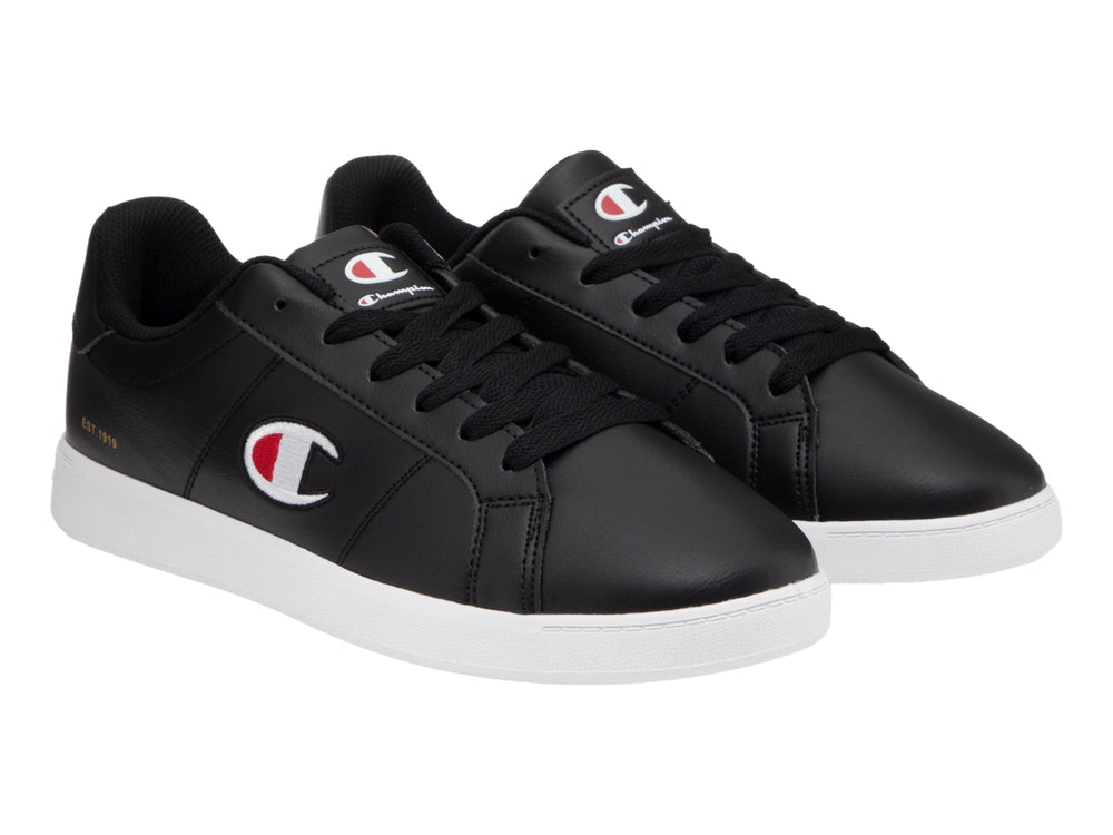 Tenis Champion color negro con suela blanca y logotipo lateral en blanco y rojo.