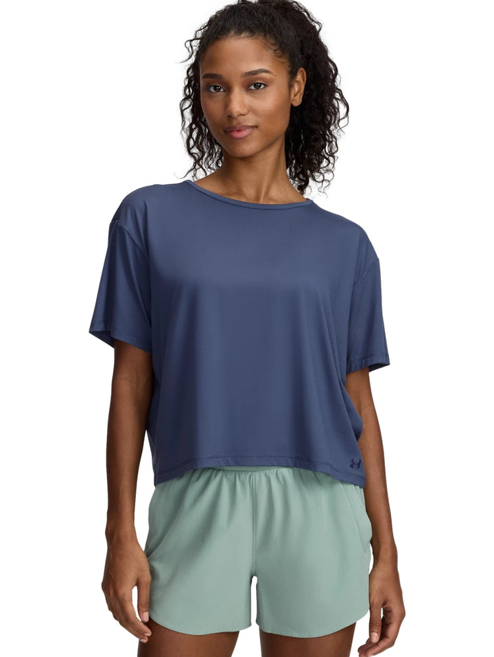 Mujer vistiendo camiseta deportiva azul marino y shorts gris claro de Under Armour.