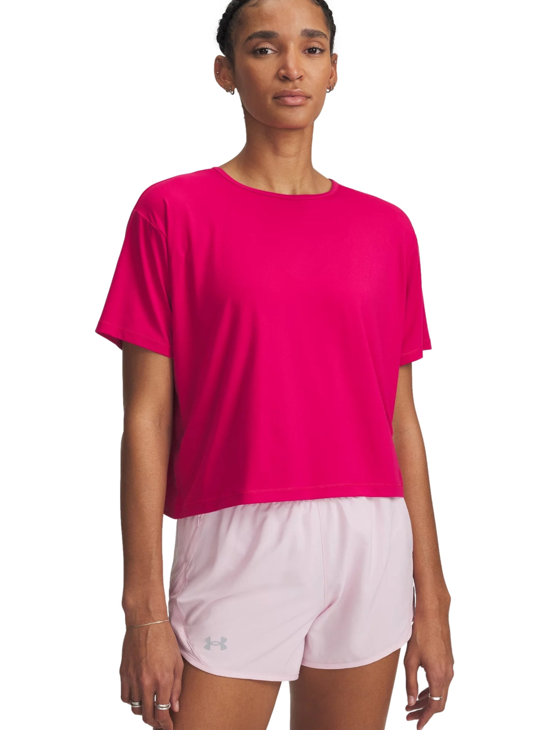 Mujer vistiendo una camiseta deportiva de manga corta color rosa intenso de la marca Under Armour.