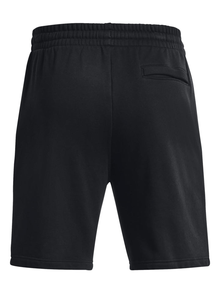 Hombre vistiendo shorts deportivos negros de Under Armour con logo blanco.