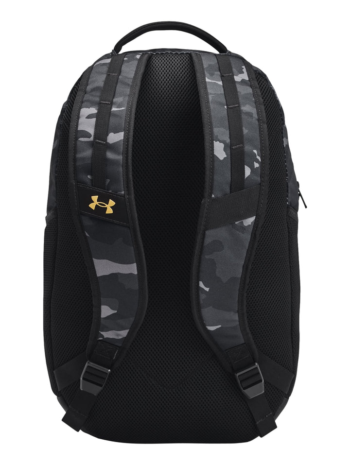 Mochila Under Armour Hustle 6.0 en color negro con estampado de camuflaje gris y logotipos en dorado.