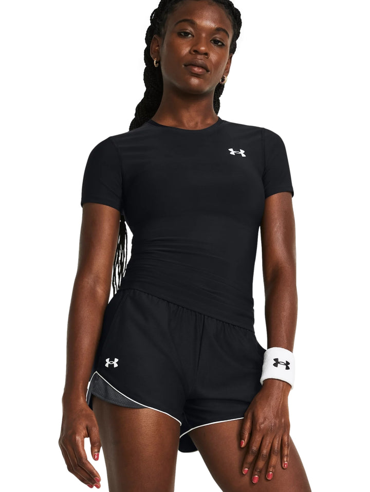Mujer vistiendo camiseta de compresión negra de manga corta Under Armour.