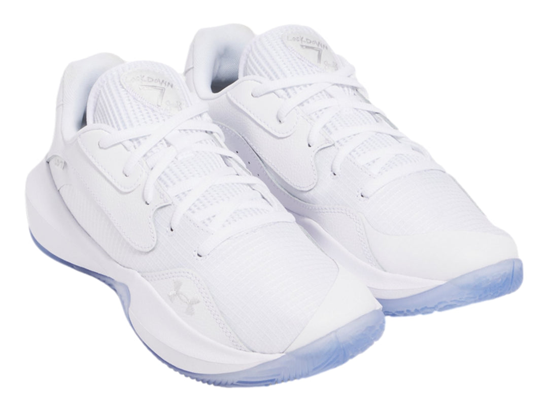 Tenis de baloncesto Under Armour Lockdown 7 Low en color blanco con detalles plateados y suela translúcida.