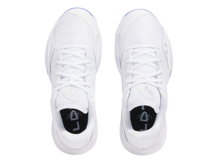 Tenis de baloncesto Under Armour Lockdown 7 Low en color blanco con detalles plateados y suela translúcida.