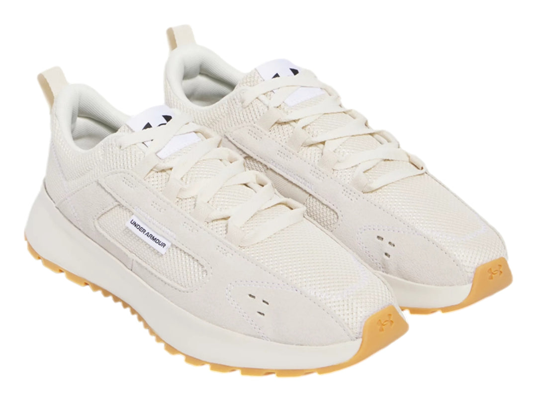 Tenis Under Armour color beige con suela de goma color café, diseño deportivo y casual.