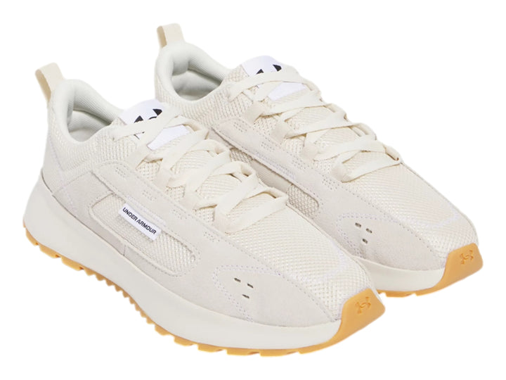Tenis Under Armour color beige con suela de goma color café, diseño deportivo y casual.